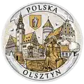 Ceramiczny magnes w formie talerza 6,5 cm z brązowym nadrukiem panorama miasta Olsztyn, herbem i postacią Mikołaja Kopernika – elegancka pamiątka turystyczna i produkt na sprzedaż hurtową B2B, POL-MP-172.